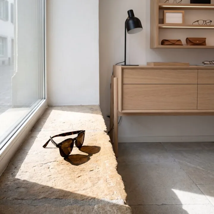 Eine Sonnenbrille in Schildpatt auf einem hellen Steinsims in der Sonne