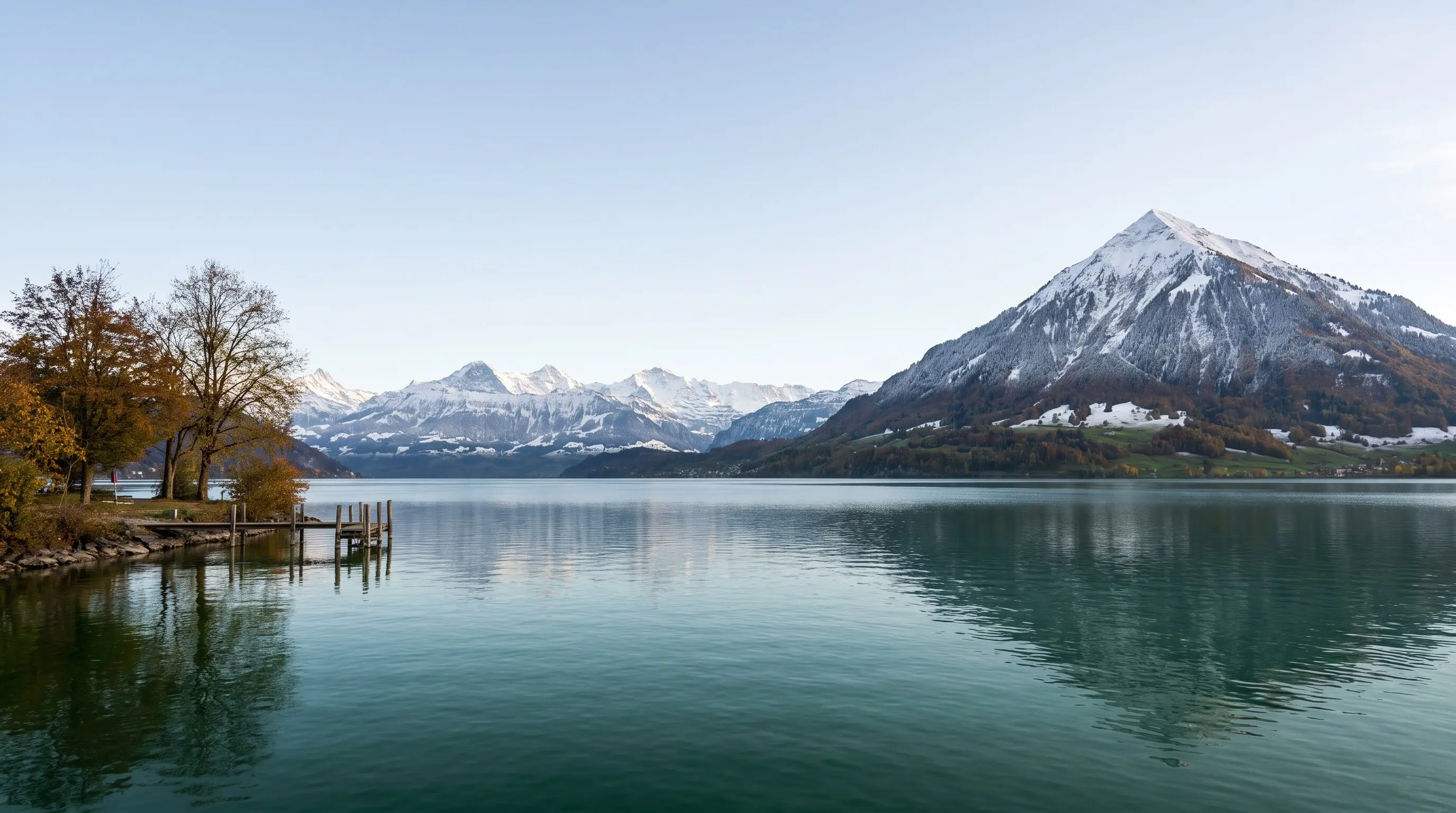 Der Thunersee am Morgen mit dem verschneiten Niesen und den Berner Alpen, vorne ein Holzsteg